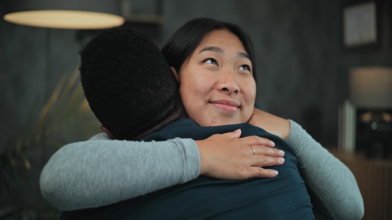 Happy Multiethnic Couple Talk and Hug after Quarrel on Couples Therapy Happy Multiethnic Couple Sit on Chairs Talk Hug and find Compromise after Quarrel on Couples Therapy Reconciliation of Tender Young Family on Counseling Session with Psychologist or Psychotherapist