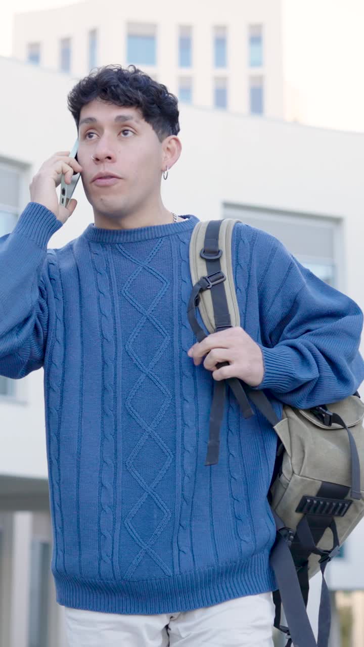 Young student talking on phone while walking. Vertical