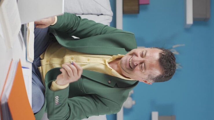 Vertical video of Home office worker old man experiencing joy.