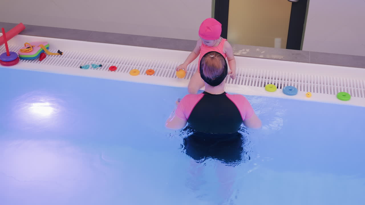 Aerial top view shows kid sitting on pool slab during break, feet near water, sunlit tiles, calm blue surface, quiet moment of rest before swim, gentle summer vibe, serene pause captured