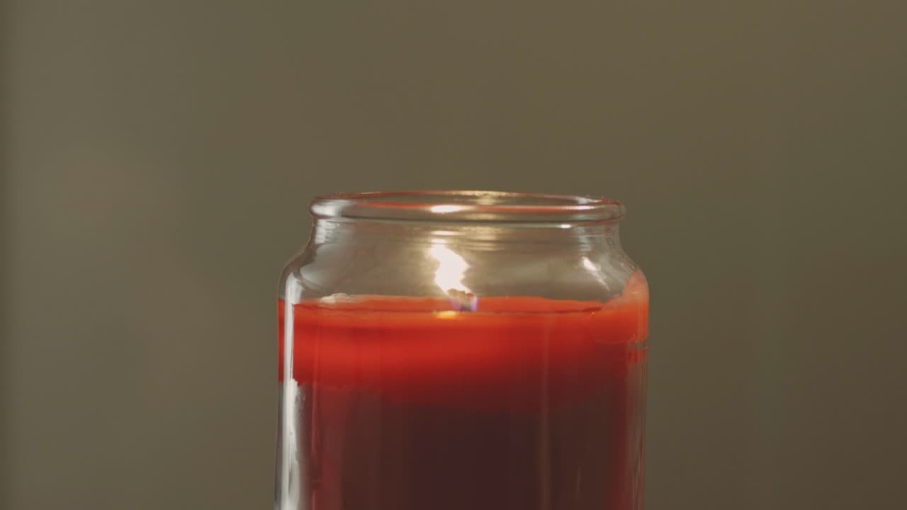 붉은 촛불이 타오르고, 유리병 안에서 불꽃이 천천히 깜박인다