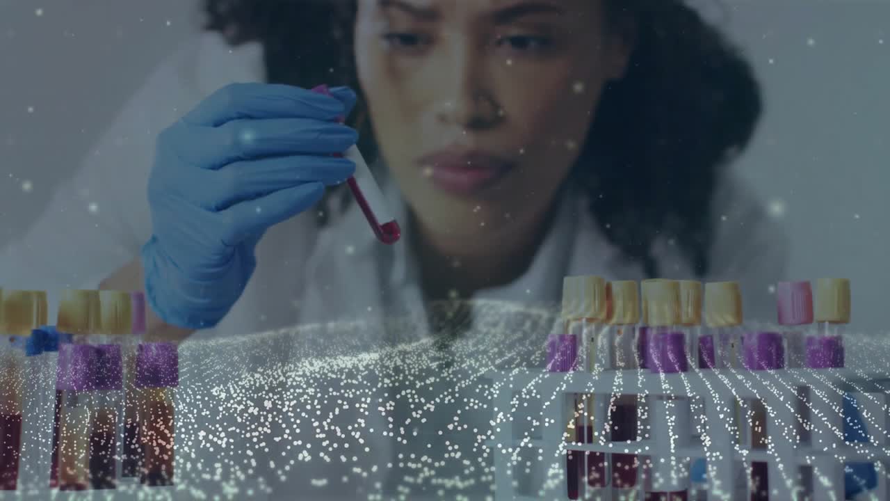 Lab technician selecting yellow tube, rotating it under light for blood analysis with particles