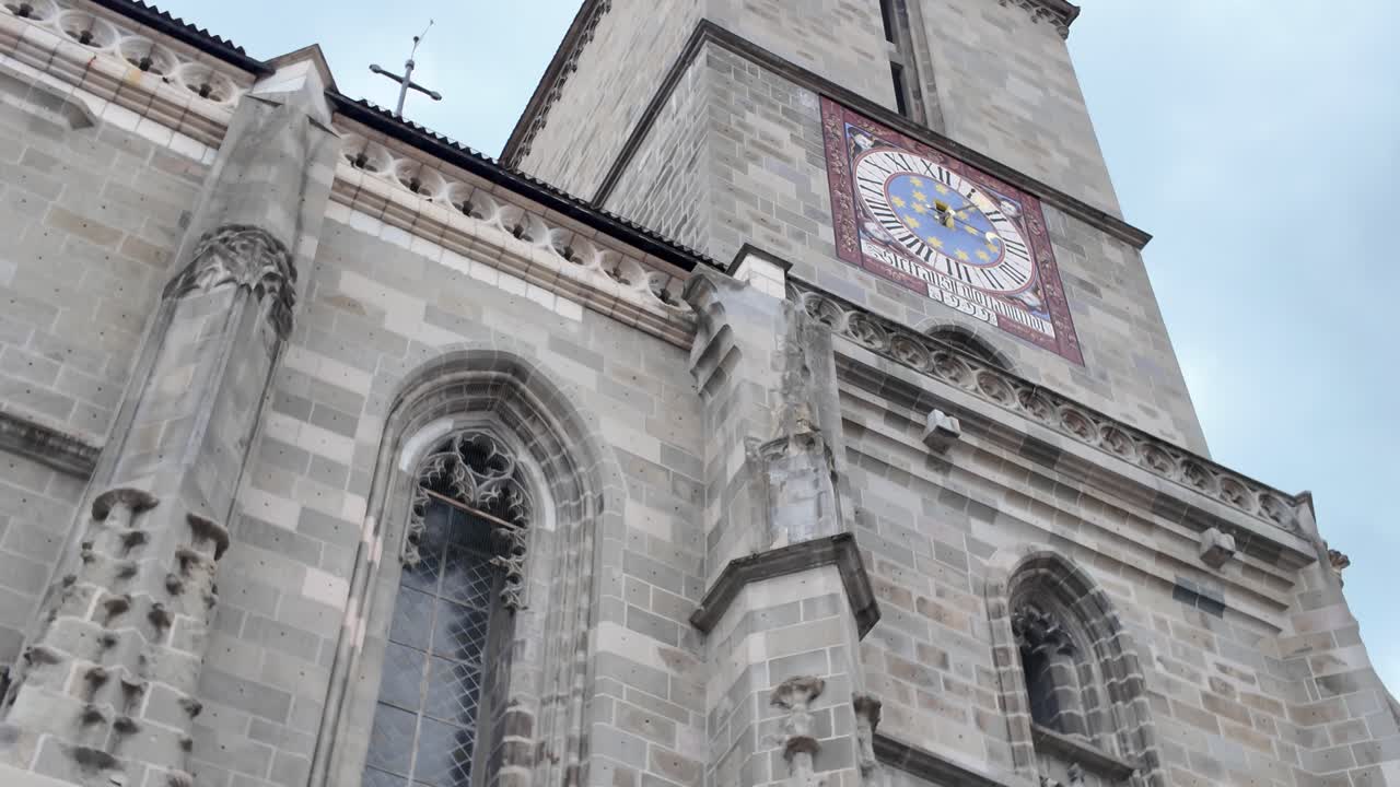 Pan upward revealing the Black Church’s historic clock tower in Brașov, showcasing Gothic architecture and exterior details