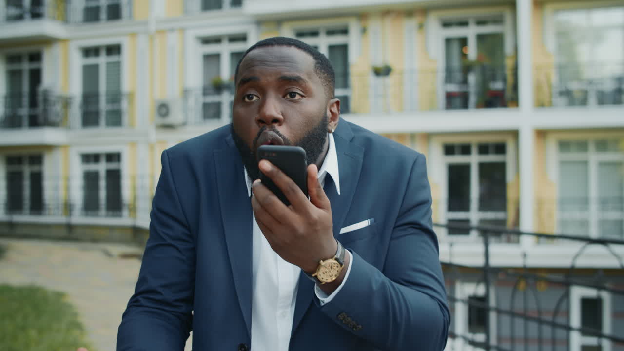 Nervous businessman talking on mobile phone outside