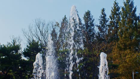 Eine-Nahaufnahme-Des-Springbrunnenwassers-Im-Park-In-Der-Herbstsaison-Mit-Bäumen-Und-Blättern-Tagsüber-Mit-Sonnenlicht