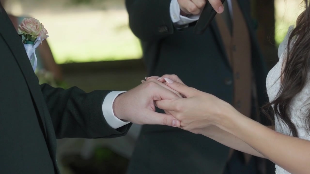Lo sposo e la sposa si tengono per mano con gli anelli
