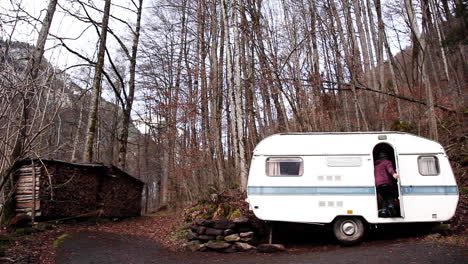 static shot of man going to truck van in autumn forest, switzerland