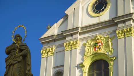 enorme iglesia con una cruz dorada encima de ella erb del condado multicolor con estatuas a su alrededor y la escultura principal en el frente de pie con halo chapado en oro ve jesucristo cree en la fe