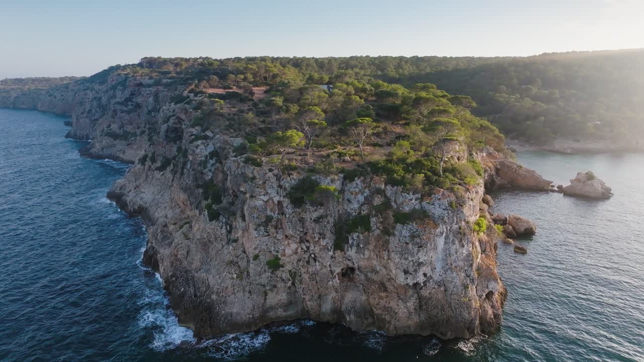 Luftoptagelse i cirkulær bevægelse omkring stejl, barsk kystkalkstensklippe, Mallorca