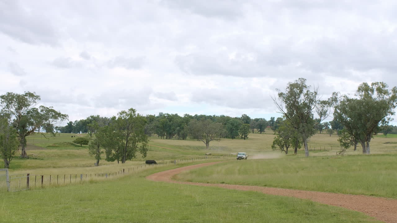 Camion Toyota Landcruiser che solleva polvere guidando velocemente su una strada sterrata rurale, Australia, 4K