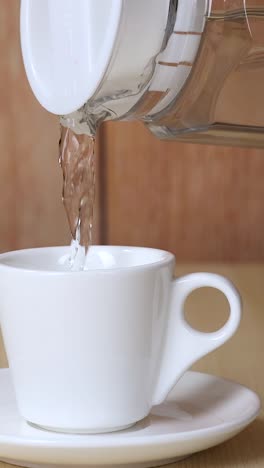 water being poured into a white cup