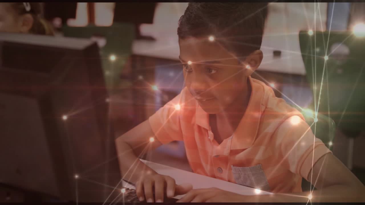 Boy placing hands on keyboard and typing, generating animated network graph in lab for learning