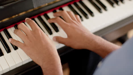 Primer-Plano-De-Las-Manos-De-Un-Hombre-Birracial-Tocando-El-Piano-En-Casa,-Cámara-Lenta