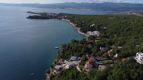 Fast-and-descending-drone-flight-from-high-altitude-along-the-Krk-Croatia-coast-with-villages-boats-and-tourists