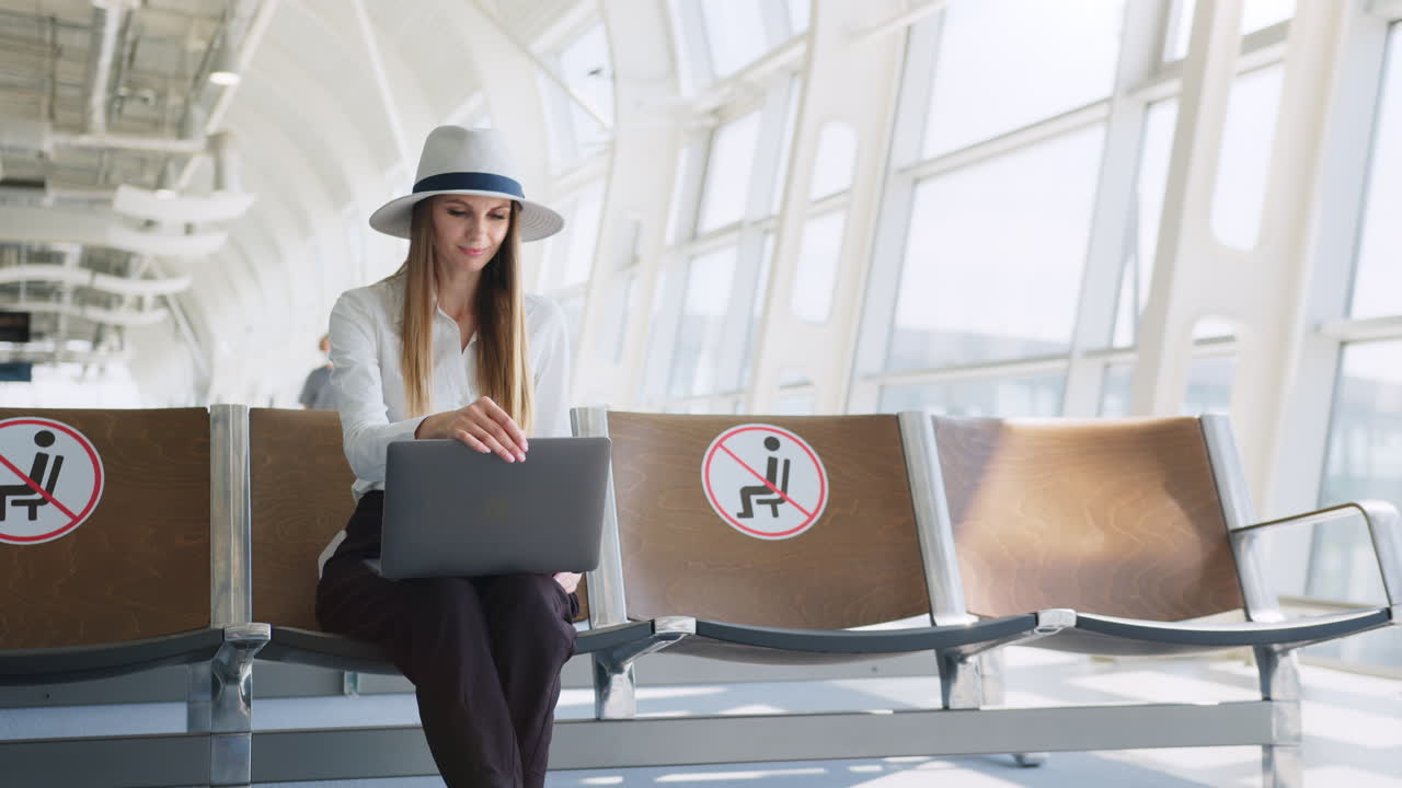 공항 터미널 에서 노트북 을 사용 하고 있는 여자