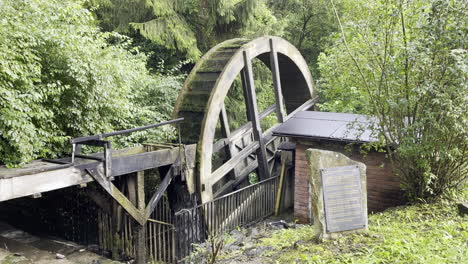 la rueda de un antiguo molino de agua es impulsada por el agua de un arroyo