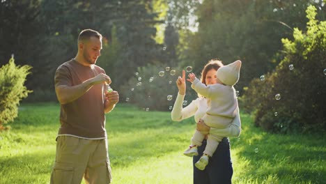 family having fun in a park with bubbles