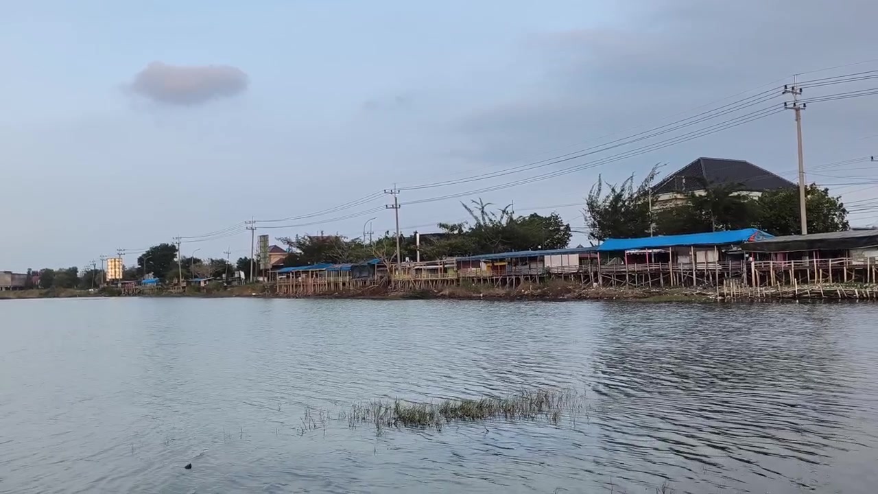Case su palafitte lungo la riva del fiume al tramonto