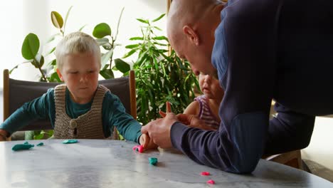 padre e hijos jugando juntos con arcilla en un hogar cómodo 4k
