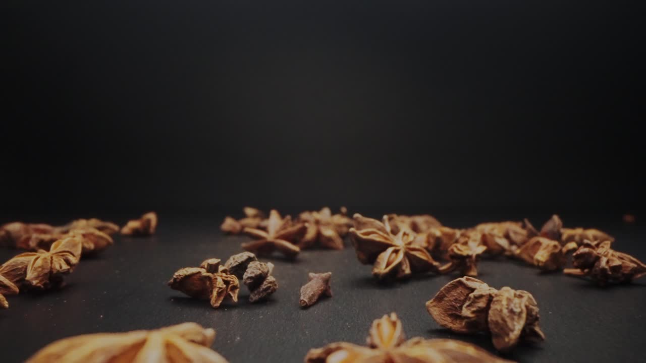 Dolly shot of falling spice on a black table in slowmotion