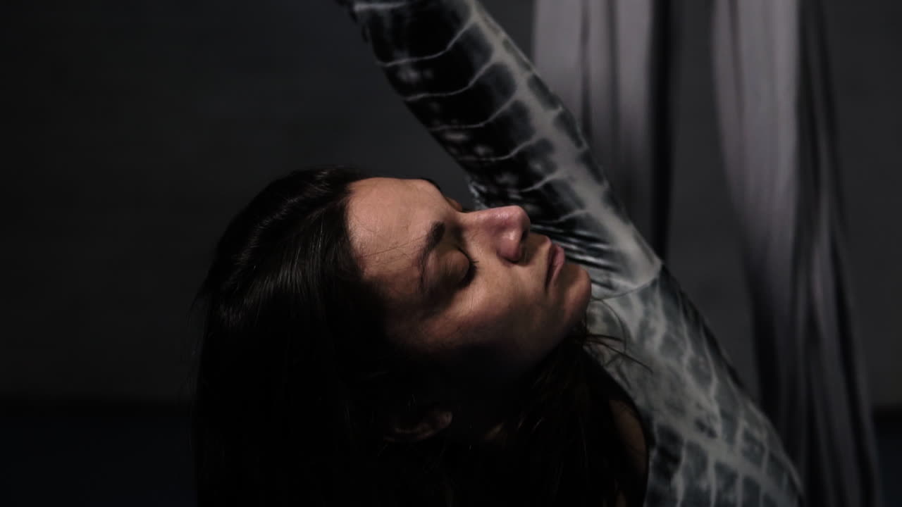 primer plano de un acróbata senior calentándose antes de una rutina de ejercicios en sedas ariales