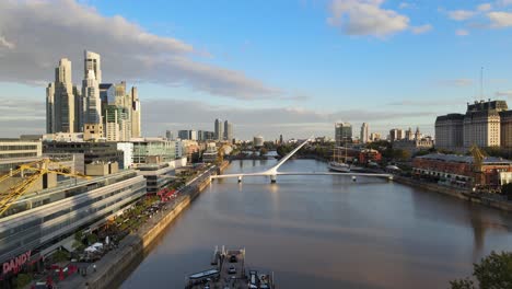 Cinematic-aerial-dolly-out-flying-between-old-port-cranes-in-Puerto-Madero-waterfront,-Buenos-Aires