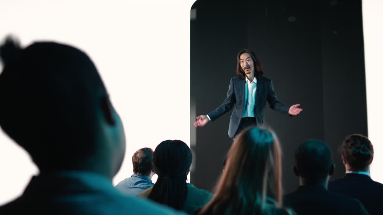 Presentatore asiatico che conduce un evento di lancio di un nuovo smartphone con presentazione di smart display