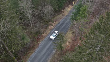 white suv car driving along tortuous mountain road