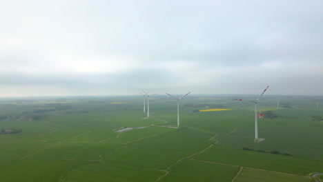 Windmühlen-Wechseln-Energie-Auf-Immergrünem-Ackerland-An-Einem-Nebligen-Morgen