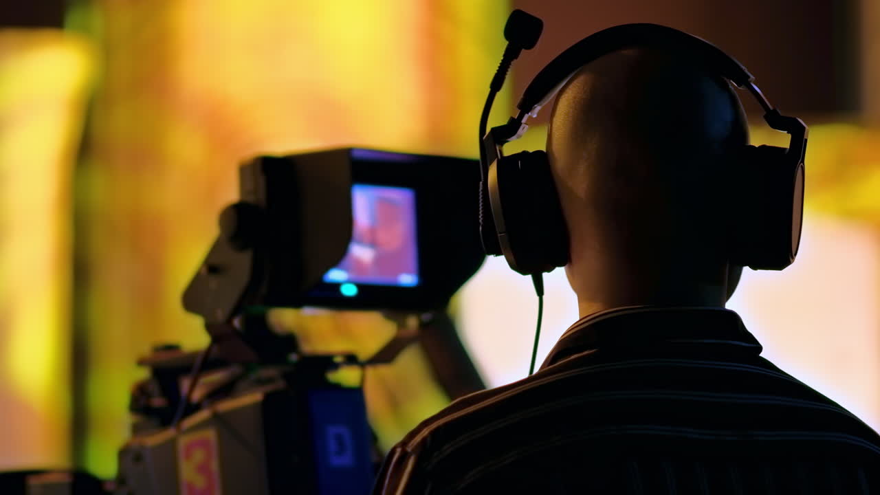 Man filming with professional camera on the backstage of a TV set