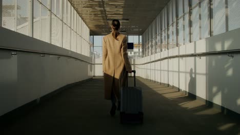 businesswoman traveling through airport bridge