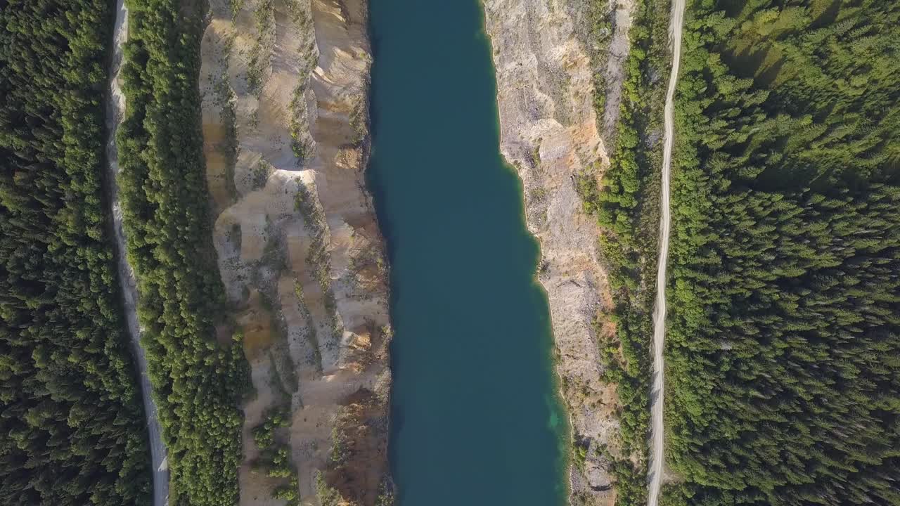 vista aérea de una cantera con un lago y el bosque circundante