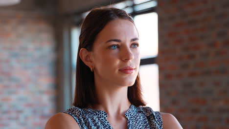 head and shoulders portrait of smiling young businesswoman standing in office