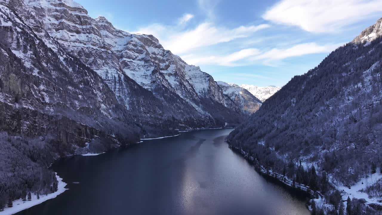 Drone flight over the alpine Lake Klöntalersee, completely frozen during Switzerland's harsh winter.