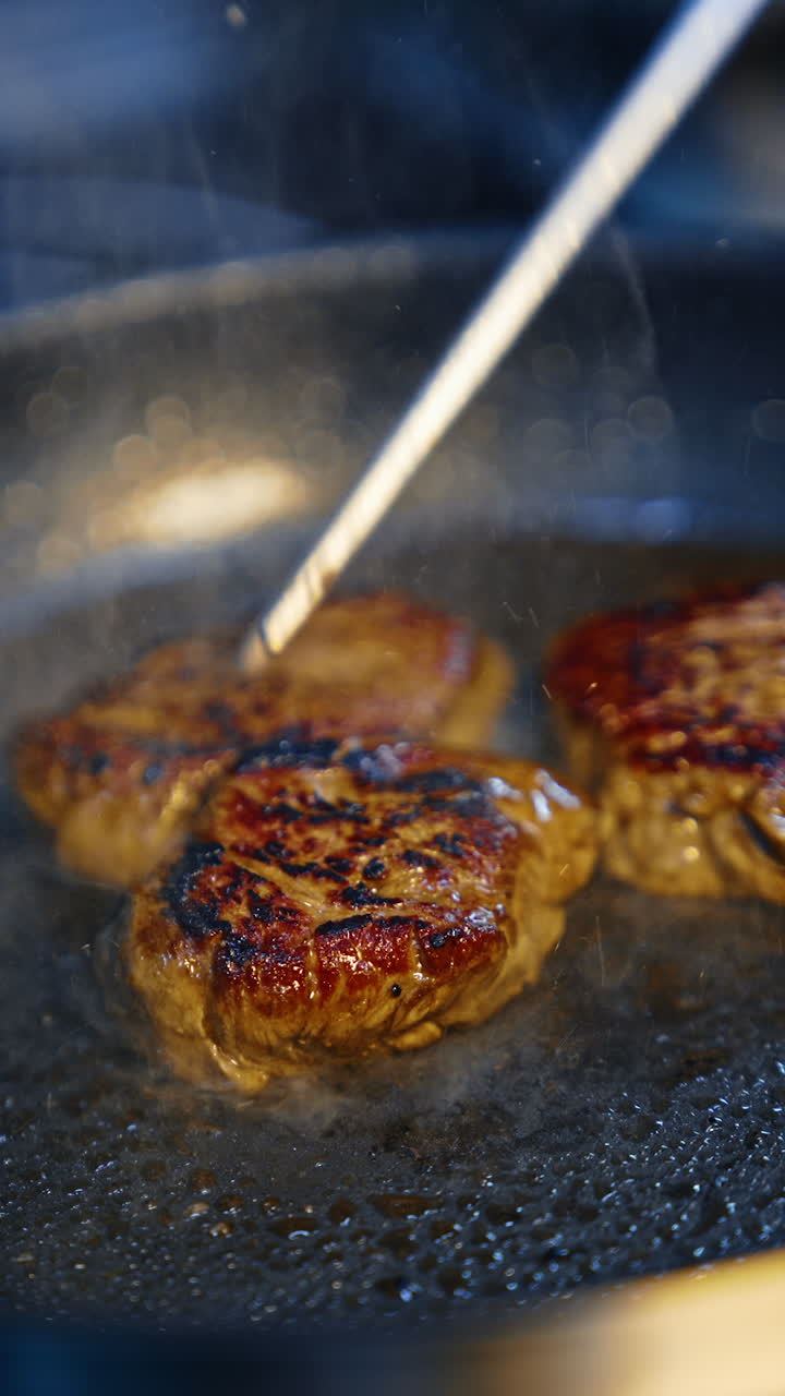Frying restaurant meat on a kitchen. Roasting tasty dinner. Vertical video.