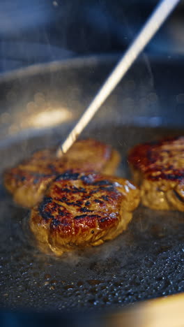 frying restaurant meat on a kitchen. roasting tasty dinner. vertical video.