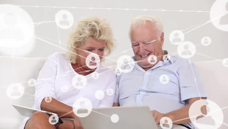 animación de la red de conexiones con personas iconos sobre pareja de ancianos caucásicos usando portátil