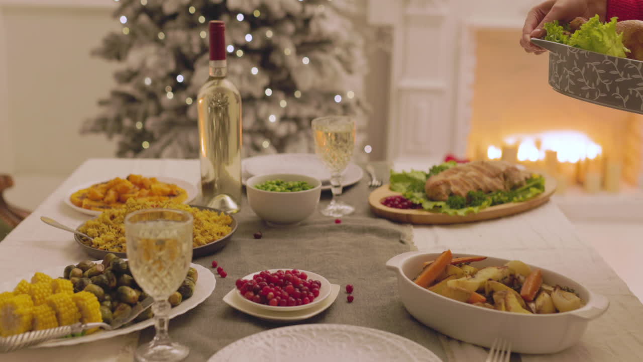 Uidentifiserbar kvinne som legger stekt kylling på julemiddagsbordet 5