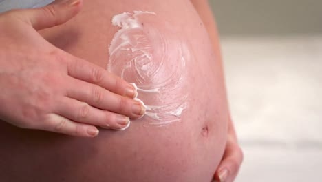 Pregnant-woman-putting-lotion-on-belly