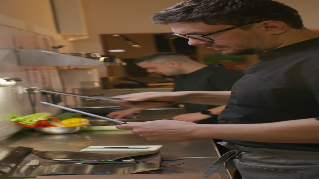 Chef che affila il coltello mentre si prepara per il lavoro nella cucina di un ristorante