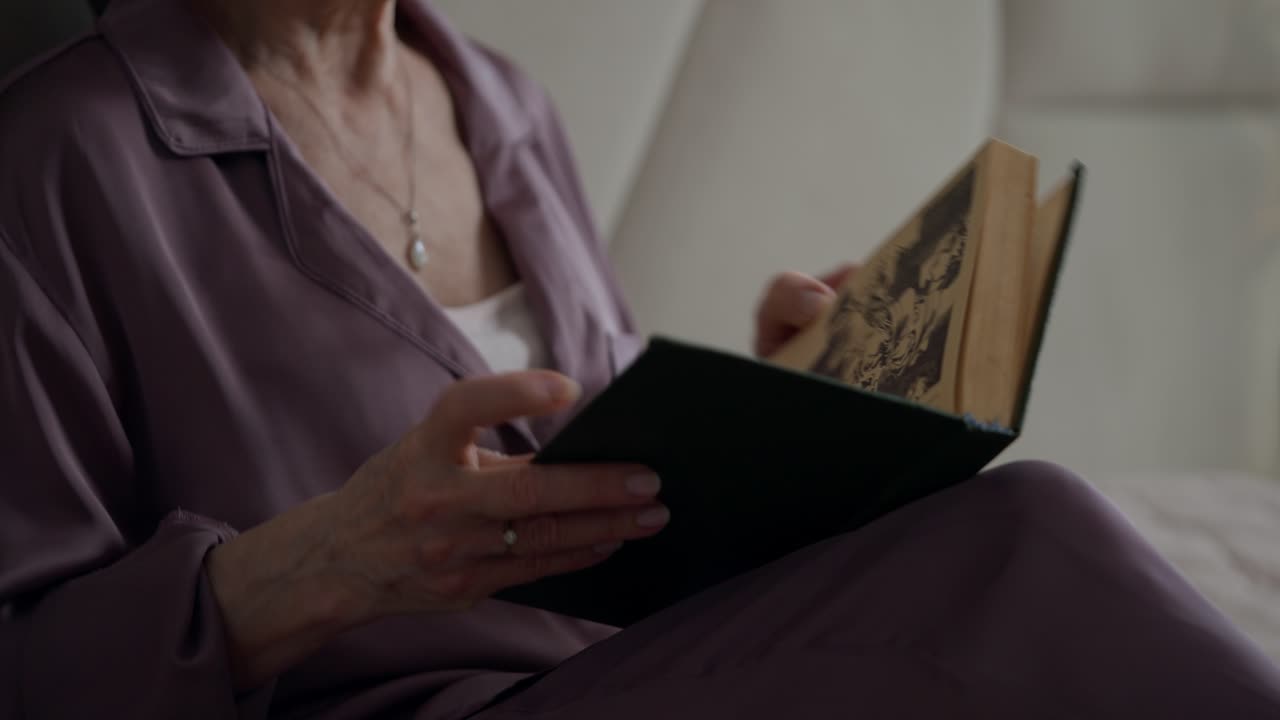 Anziana signora che legge un libro nella sua camera da letto