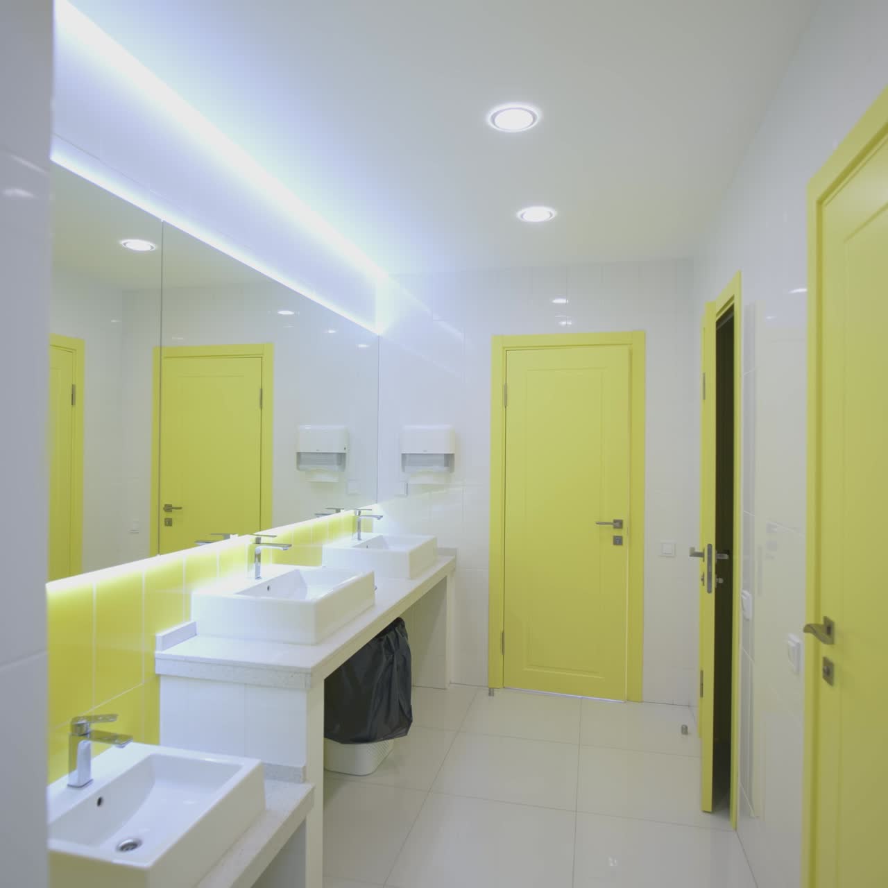 Modern toilets in clinic. White and yellow sterile water closet with wash basins in the hospital. Hygiene during quarantine