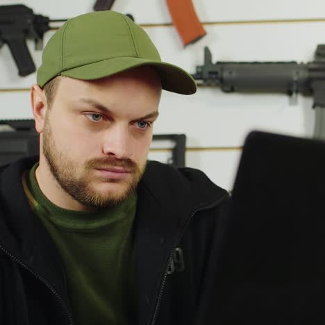 man behind a counter in an arms store 7