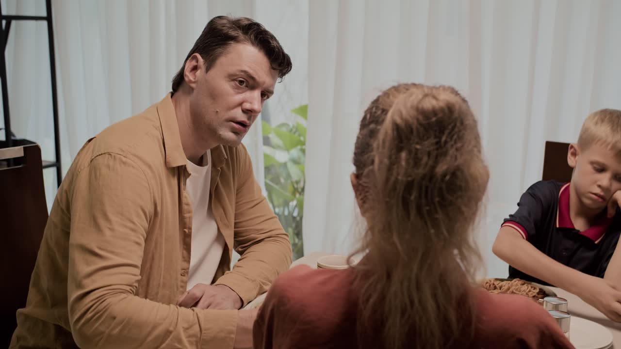 Spouses Having Tense Talk during Family Dinner with Son