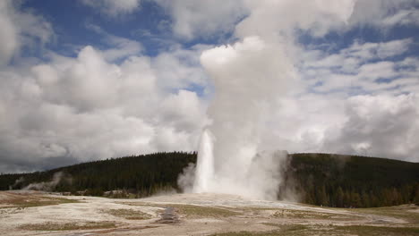 Old-Faithful-geyser-Yellowstone-National-Park-erupting-blue-sky