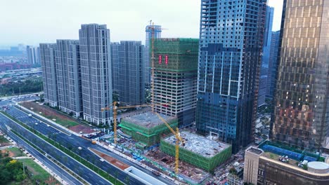 Aerial-view-of-high-rise-buildings-of-Yiwu-International-Trade-Market,-office-spaces-and-dynamic-highway-traffic,-embodying-global-commerce's-vibrant-essence