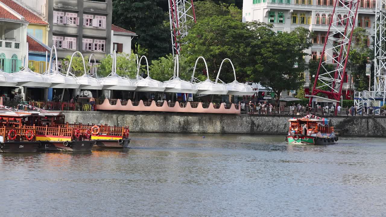 Traditional river cruise boat passes colorful riverside buildings and outdoor dining at urban waterfront