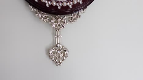 ornate wall clock with decorative pendulum
