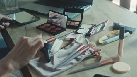 woman applying makeup at a table