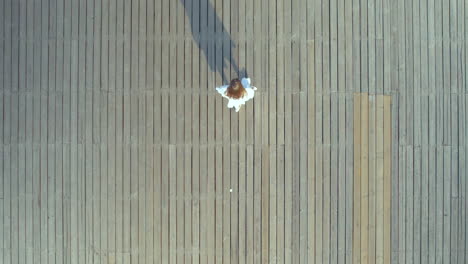 ⁇ 색 여름 드레스를 입은 예쁜 여성이 해가 뜨면 나무 기 ?? 을 따라  ⁇ 고 있습니다. orlowo, gdynia, poland - aerial tracking top down